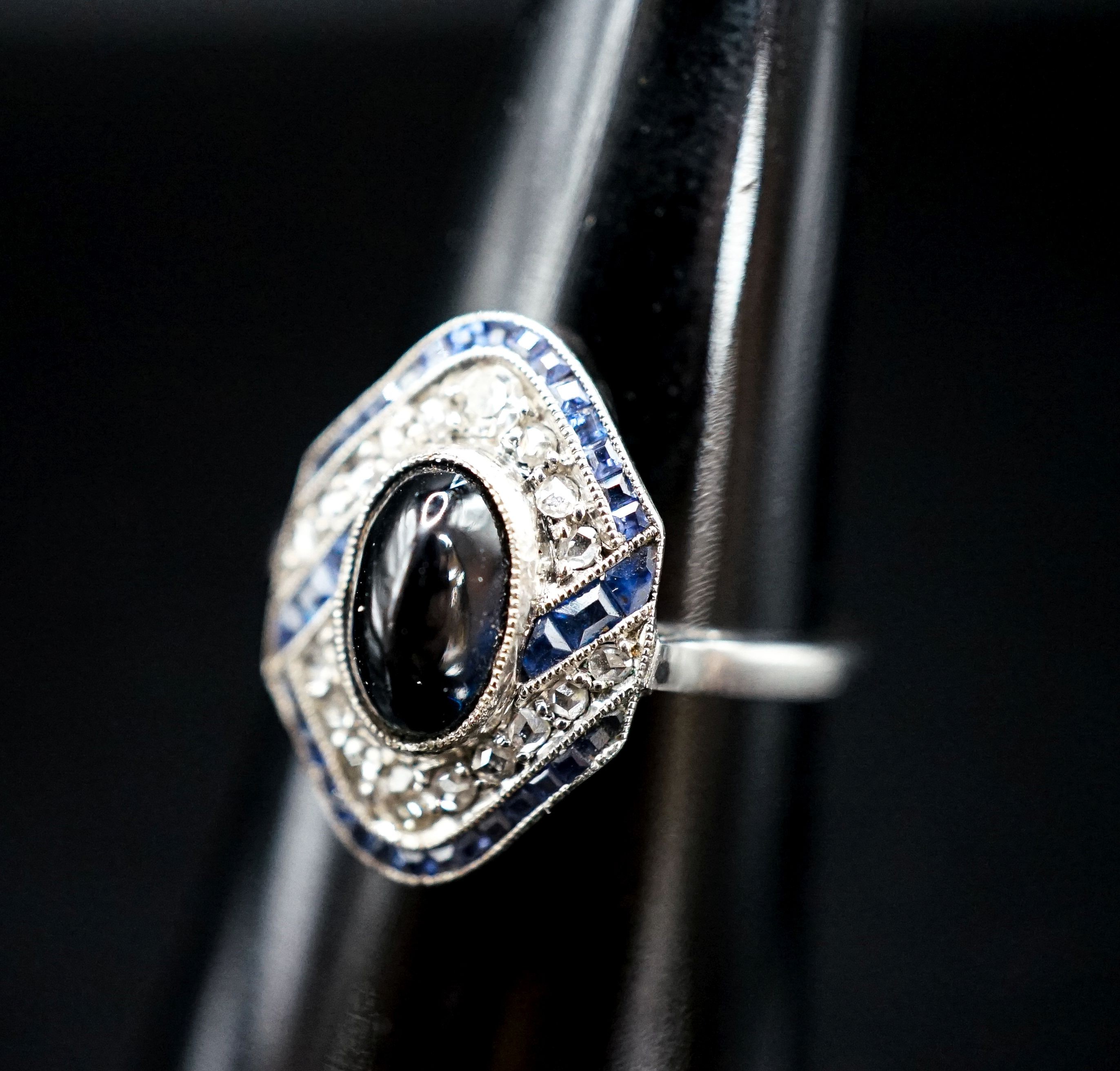 A 1920's white metal (stamped plat), sapphire and diamond ring, with central cabochon sapphire, size M, gross weight 4.6 grams.